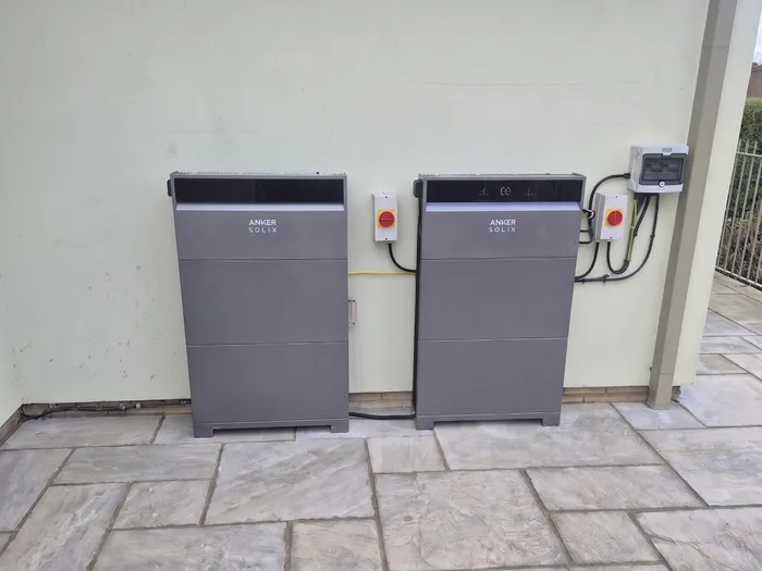 Two Anker Solix home battery storage units installed on an exterior wall